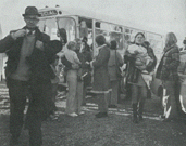 Black and white photo of people getting off bus.