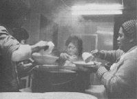 Black and white photo of people preparing food.