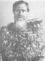 Man with beard and moko wearing kahu huruhuru/feather cloak.